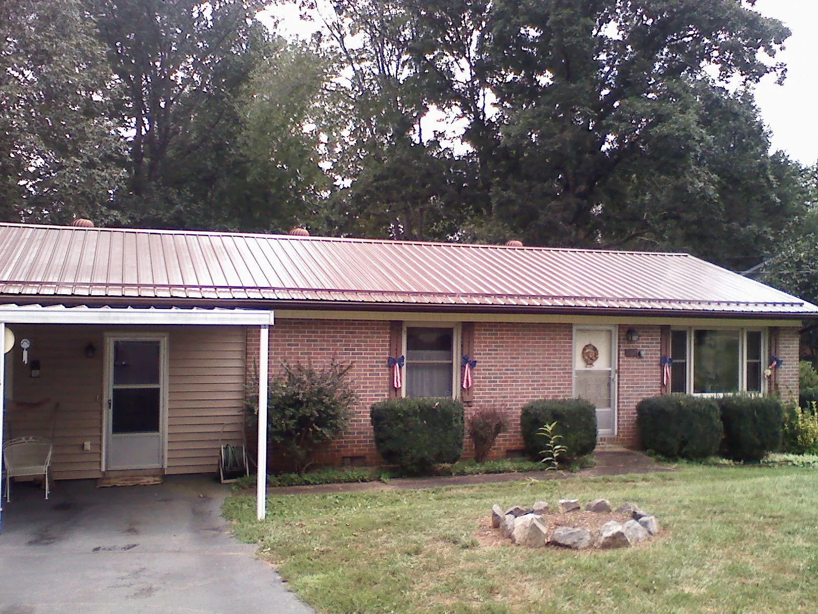 Bronze metal roof and carport on a brick ranch home — Roof Repair work by our crew in Commerce